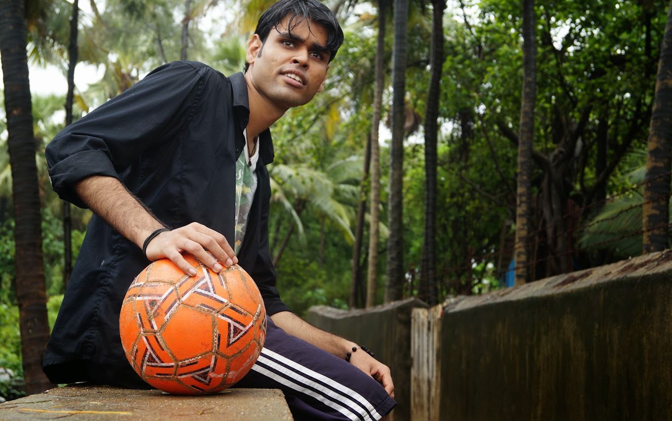 Energetic portrait of a football player holding an orange ball