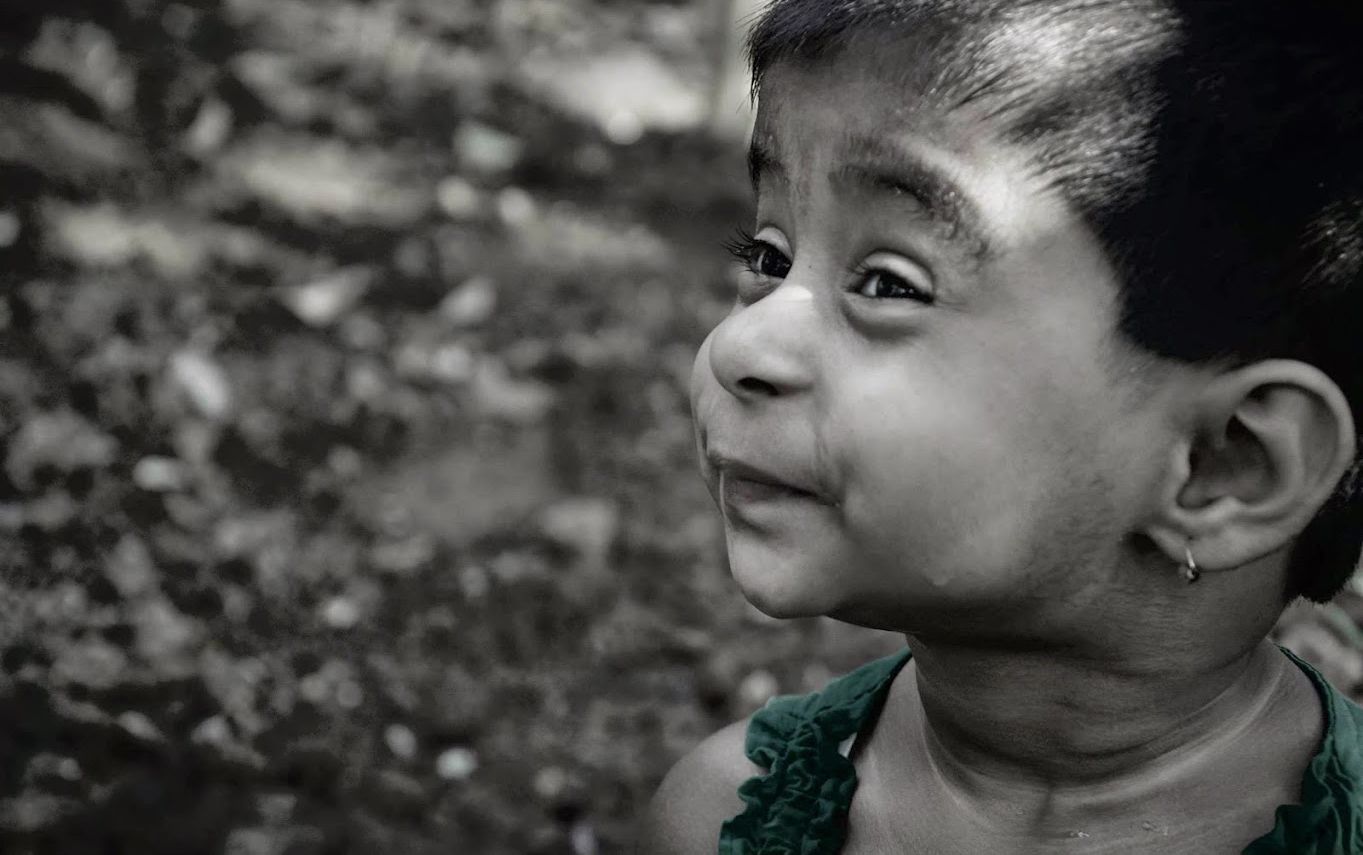 Black-and-white close portrait of an expressive child