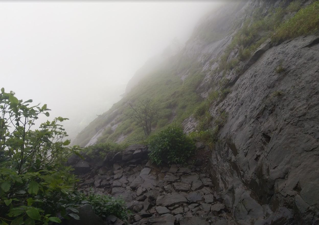 Misty mountain cliff disappearing into fog